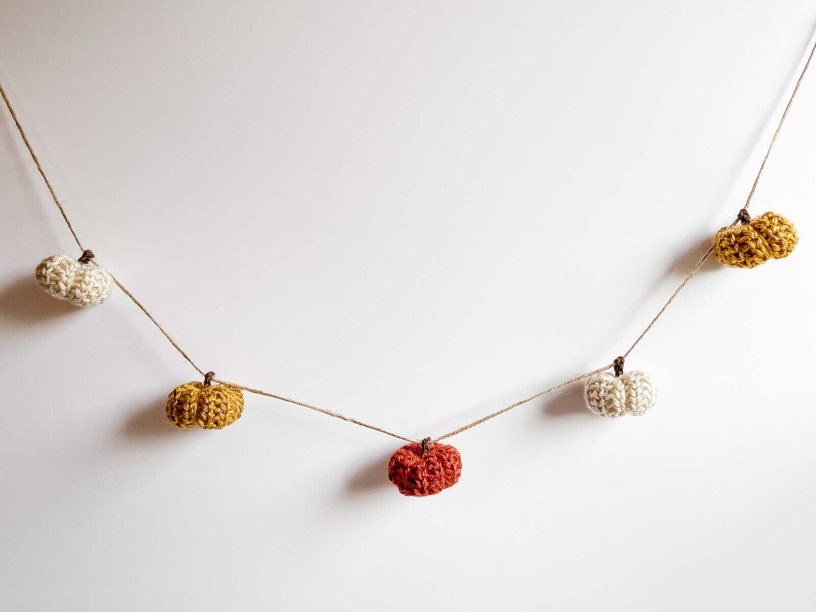 Rustic crochet mini pumpkin garland: small textured pumpkins in fall colors